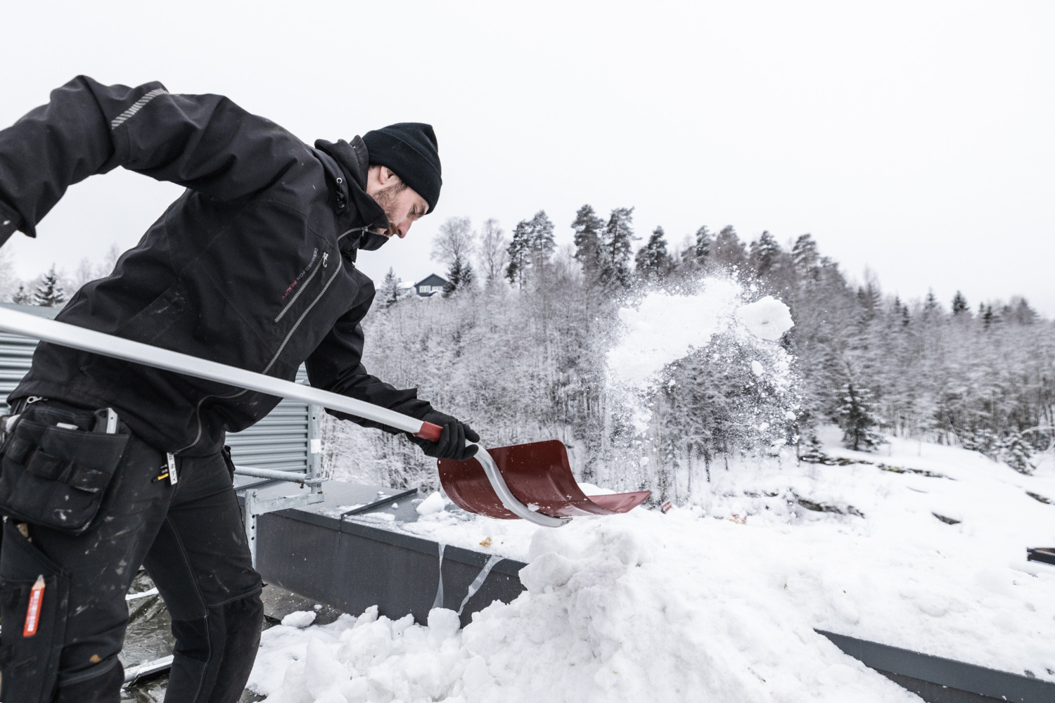 Takarbeider måker snø fra tak